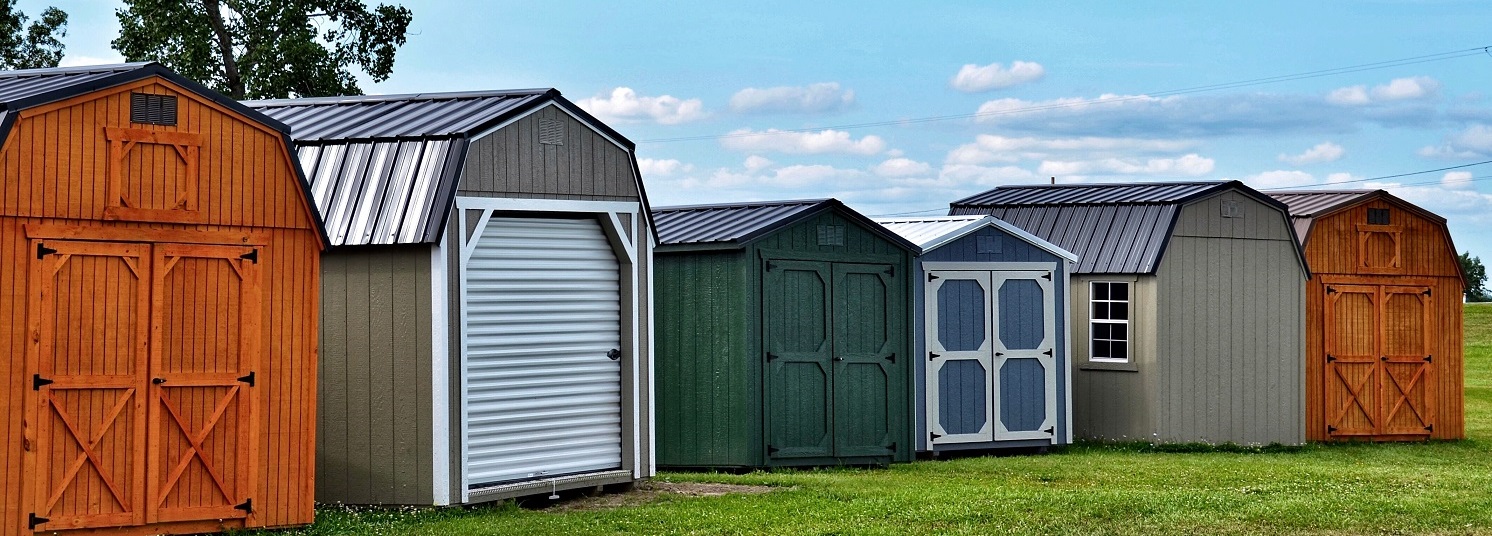Various styles of wooden sheds on display.